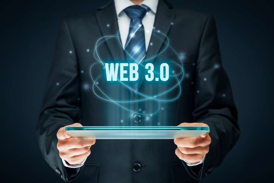 Un homme en costume tient une tablette transparente affichant l'inscription Web 3.0 entourée d'un champ d'énergie lumineuse.